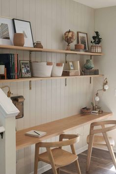 two wooden chairs sitting next to each other on top of a desk in a room