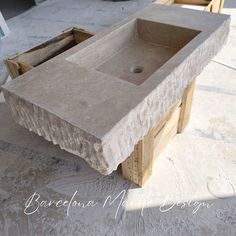 a stone sink sitting on top of a wooden table