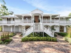 a large white house with lots of balconies on the upper floor and second story