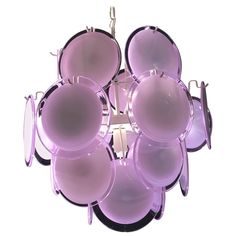 a purple light hanging from the ceiling with lots of pans on it's sides