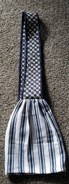 a blue and white striped tie laying on top of a floor next to a bag