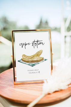 a card with a banana on it sitting on top of a wooden table next to a feather