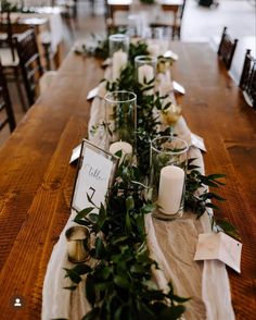 the long table is set with candles and greenery