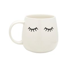 a white coffee mug with eyelashes on it