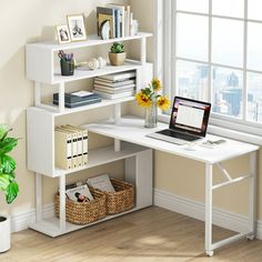 a laptop computer sitting on top of a white desk next to a plant and bookshelf