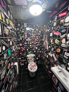 a bathroom with many stickers all over the walls and floor, along with a toilet