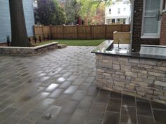 a brick patio with an outdoor kitchen and sink