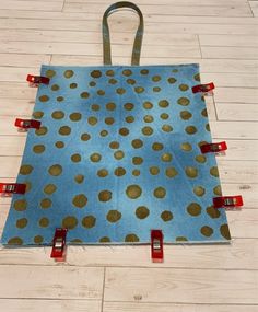 a blue bag with gold polka dots on it sitting on the floor next to some red tape