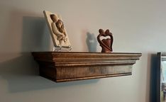 two wooden sculptures on top of a shelf