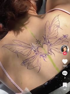 a woman with a butterfly tattoo on her back