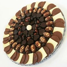 a cake with chocolates and nuts arranged in the shape of a circle on a platter