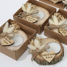 wedding favors in boxes with feathers and hearts on the top, tied to burlocks