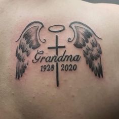 the back of a man's shoulder with an angel cross and wings on it