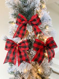 a christmas tree decorated with red and black plaid bows