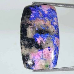 a close up of a piece of metal with blue and pink paint on it's surface