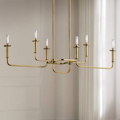 a large brass chandelier with five candles hanging from it's center rod