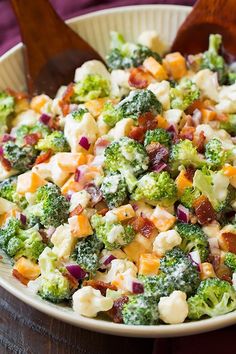 a bowl filled with broccoli, cheese and other food on top of a table