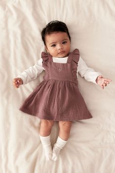 Set with a dress in cotton muslin and a bodysuit in soft cotton jersey. Dress with ruffle-trimmed shoulder straps crossed at back  a square neckline  an embroidered detail at front  and covered elastic at back of midsection. Shoulder straps with concealed snap fasteners at front. Bodysuit with snap fasteners on shoulders  long sleeves with concealed elastic at cuffs  and snap fasteners at bottom for easy changing. Dark Dusty Pink, Cotton Jersey Dress, Kids Dress Patterns, Cotton Plant, Snap Fasteners, Cotton Muslin, Muslin Cotton, Newborn Outfits