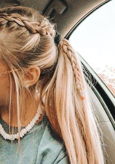 a woman sitting in the back seat of a car with her hair in a pony tail braid