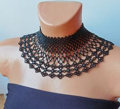 a black crocheted choker on a mannequin neckline is shown