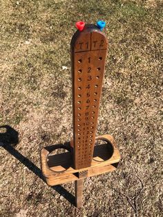 a wooden grater sitting on top of a grass covered field