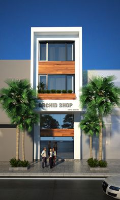 two people are standing in front of a building that has palm trees on the sidewalk