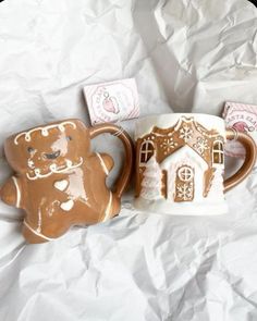 two mugs that have been decorated with gingerbread cookies and a house on them