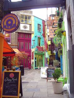 an alleyway with many colorful buildings and signs