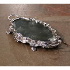 an ornate silver tray on the ground