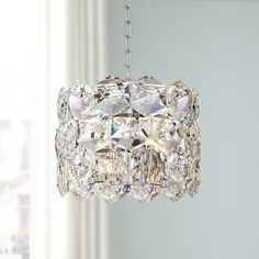 a crystal chandelier hanging from a ceiling in a room with white walls and windows