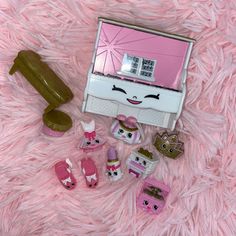 there are many small toy items on the pink fur surface, including a tv and other accessories