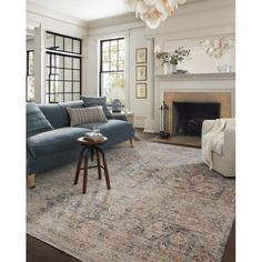 a living room filled with furniture and a fire place under a chandelier hanging from the ceiling