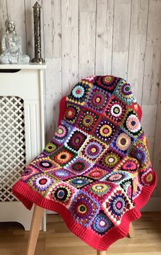 a colorful crocheted blanket sitting on top of a wooden chair