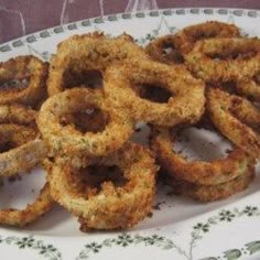 fried onion rings on a white plate with green floral design around the edges and bottom