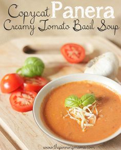 a bowl of tomato soup on a cutting board