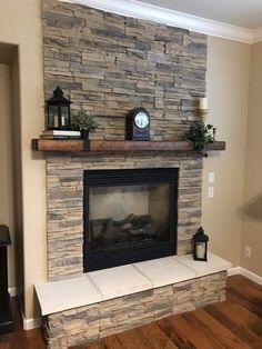 a living room with a stone fireplace and mantle