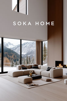 a living room filled with furniture and a large window covered in snow capped mountains behind it