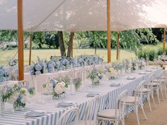 the tables are set with blue and white striped linens for an outdoor wedding reception