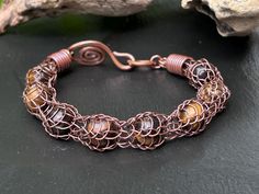 This beautiful bracelet is entirely handmade designed and created by me.  The metal is solid copper and it was salvaged from an old electrical extension cord. The chain is woven from a single piece of 24 gauge copper wire using the Viking knit technique. The beads are made of natural tigers eye gemstone and they are perfectly captured and secured onto the chain.  Comfortable and versatile it is also very light and flexible, the hook clasp makes it easy to put on and off.  Please make sure to mea Viking Knit Jewelry, Tigers Eye Bracelet, Woven Jewelry, Knit Jewelry, Viking Knit, Tiger Eye Bracelet, Tigers Eye Gemstone, Extension Cord, Eye Bracelet