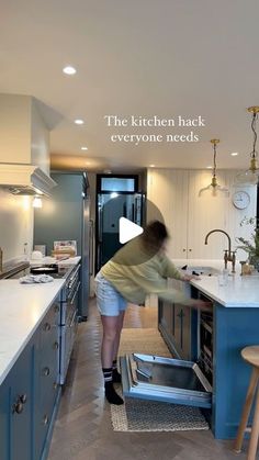 a woman is standing in the middle of a kitchen