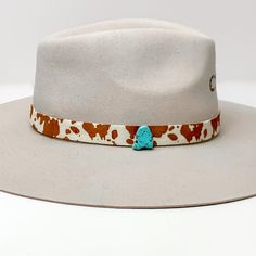 Cow Print Hat Band with Faux Turquoise Charm in Brown, and Ivory. Pictured on a white background with the band around a light tan/ brown hat. Cheap Adjustable Outdoor Hat Bands, Casual Solid Color Cheap Hat Bands, Luxury Adjustable Cream Hat Band, Cheap Pink Western Hat Bands, Cow Print Hat, Cowhide Print, Turquoise Charm, Giddy Up Glamour, Hat Band