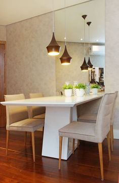 a dining room table with four chairs and a vase on the center island in front of it