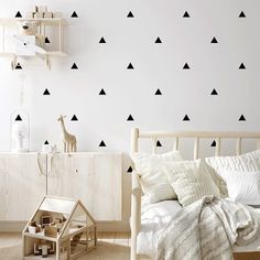 a white bedroom with black triangles on the wall