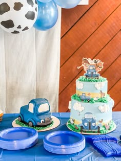 a blue table topped with a cake and plates