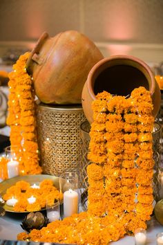 an arrangement of flowers and candles on a table