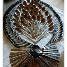 an assortment of spoons and forks arranged in a fan shape on a white tablecloth