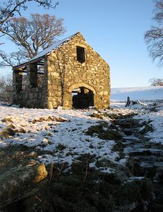 an old stone building sitting in the snow