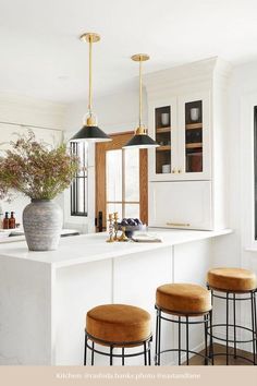 three stools sit at the center of a kitchen island