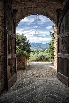 an open door leading to a scenic view over the countryside and hills in the distance