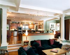 a living room filled with furniture next to a kitchen